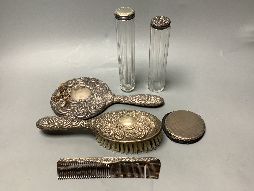 Two silver-topped narrow cylindrical toilet bottles, a silver backed-hand mirror and matching hairbrush, a comb and a silver compact